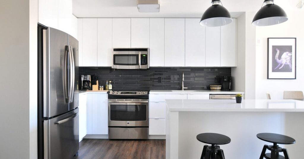 Staged kitchen Staged kitchen with white cabinets, an island and bar stools
